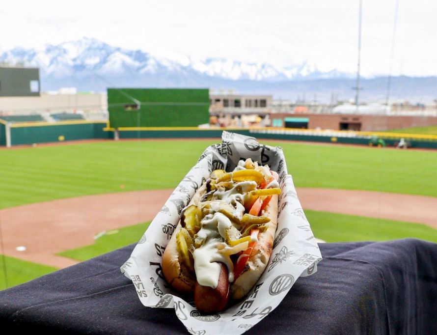 Stadium hot dog served on custom printed greaseproof paper at a baseball game