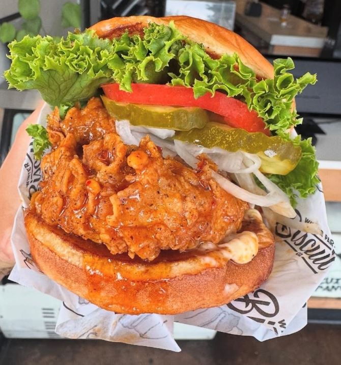 Greasy cheeseburger and fries served on food paper, showing why greaseproof burger wrap matters for presentation