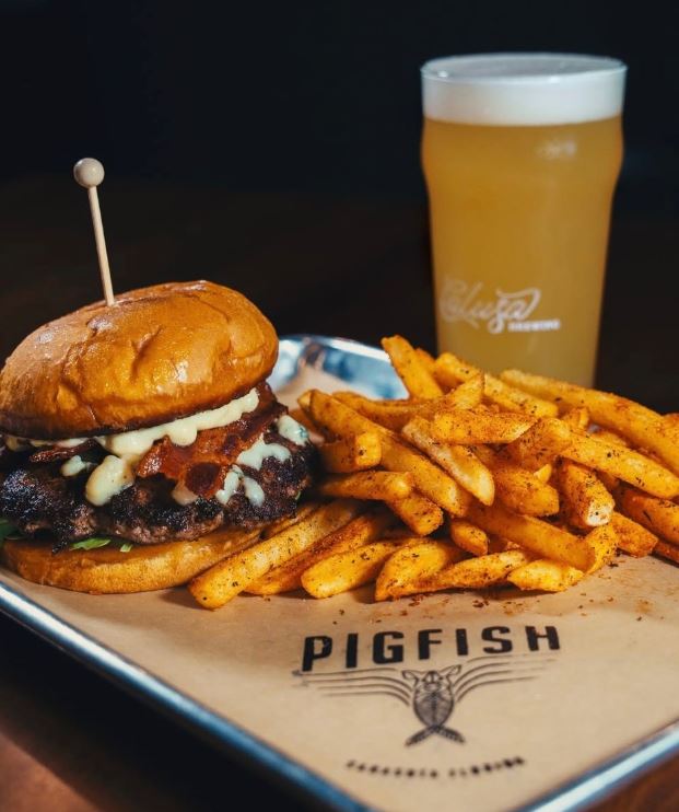 Pigfish Brewery burger, seasoned fries, and beer served on custom branded greaseproof paper